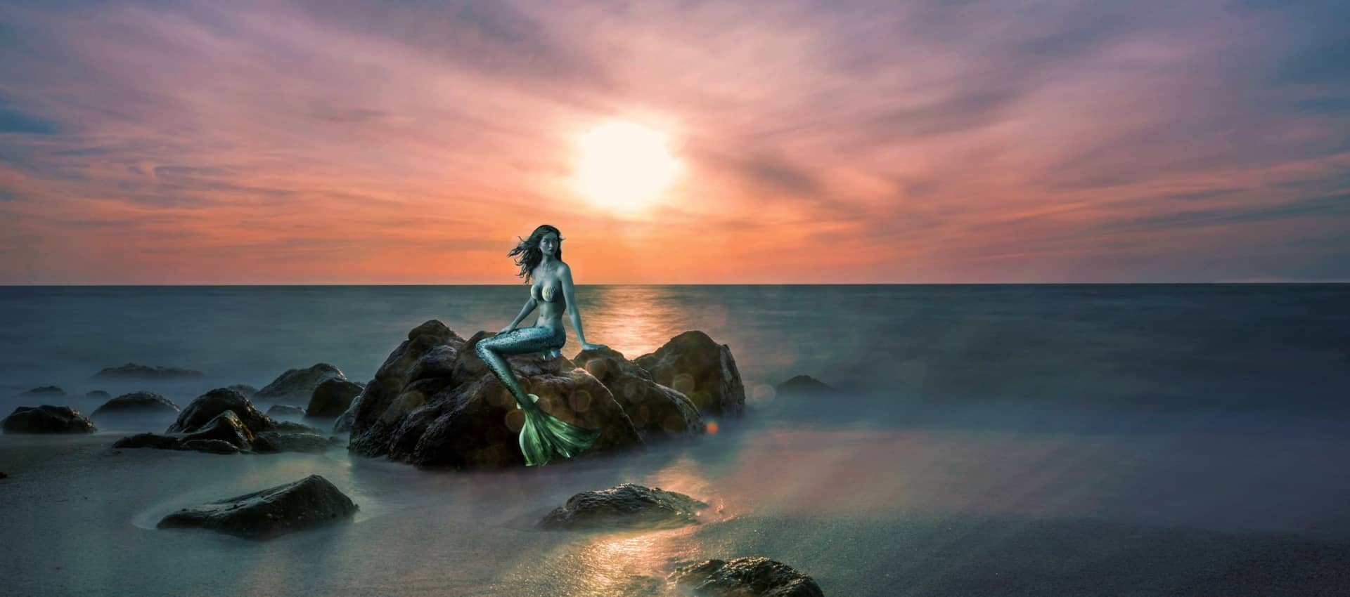 mermaid on rock with sun and ocean behind her